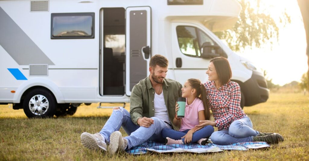 A family on a picnic beside their RV.